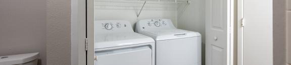 a white laundry room with two washes and a toilet