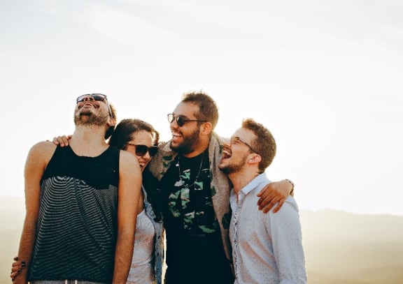 Picture of a group of four friends laughing outside