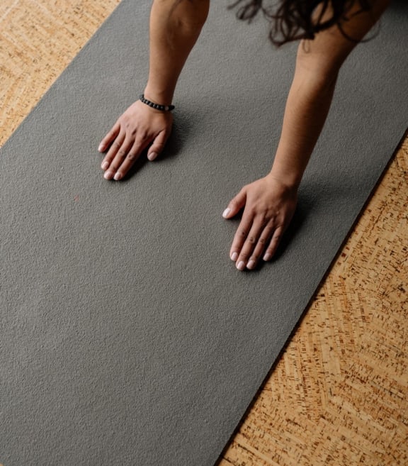 a woman with her hands on a yoga mat