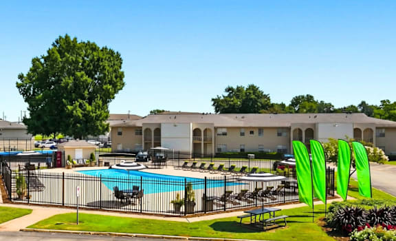 A pool surrounded by a fence with a green flag on it.
