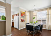Thumbnail 13 of 50 - Spacious dining room with wood grain plank flooring, oversized windows, spacious kitchen with white appliances and side by-by-side refrigerators The Lanesborough Apartments in Houston.