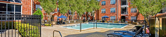 Luxury apartments with large swimming pool, spa, and large sundeck with poolside lounge chairs at The Lanesborough Apartments in Houston.