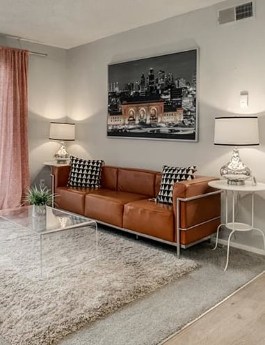 a living room with a brown couch and a green chair at Aspen Landing, Kansas City, MO, 64137