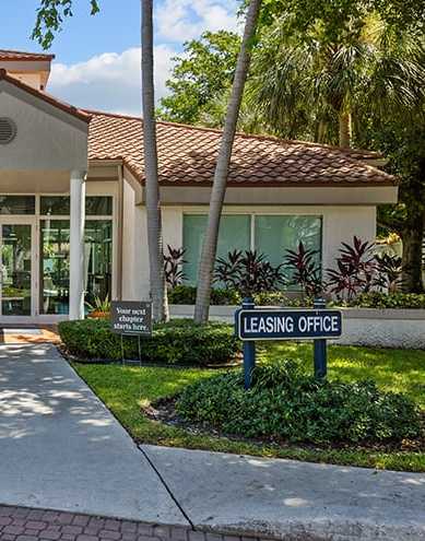 A building with a leasing office sign in front of it.