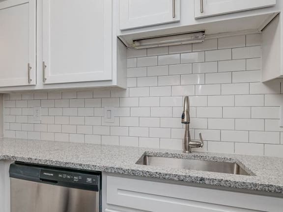 a kitchen with white cabinets and a sink