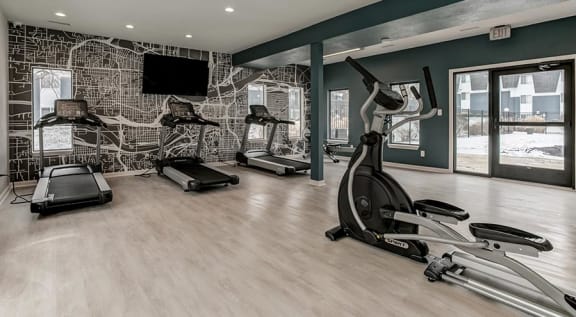the gym has a wall mural of gym equipment at Aspen Landing, Kansas City, MO, 64137