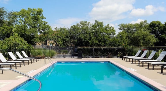 a swimming pool with white chairs around it at Aspen Landing, Kansas City, MO