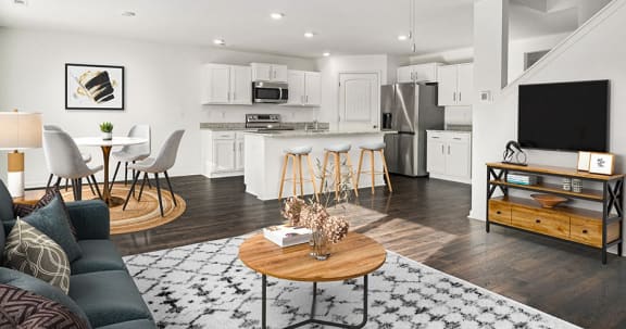 a living room with a couch and a table in front of a kitchen