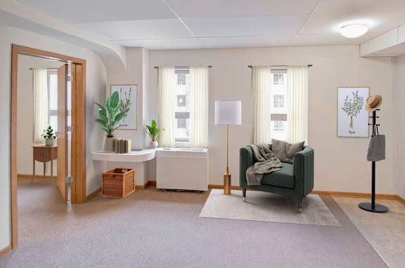 A living room with a green couch and a white table.