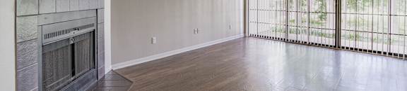 an empty living room with a fireplace and sliding glass doors