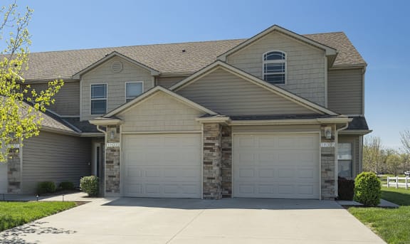 A two-story house with a garage and a driveway.