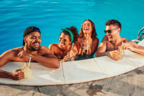 group of people in a swimming pool drinking cocktails