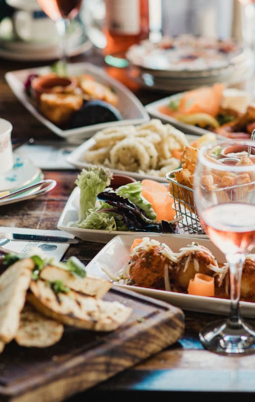 a table filled with plates of food and a glass of wine