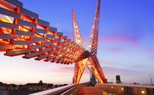 a view of a crane on a bridge at sunset