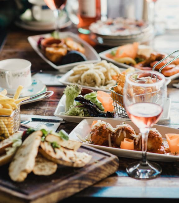 a table filled with plates of food and a glass of wine