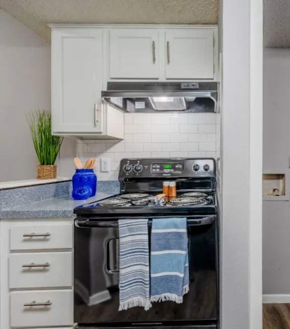 A black stove top oven with a blue towel on it.