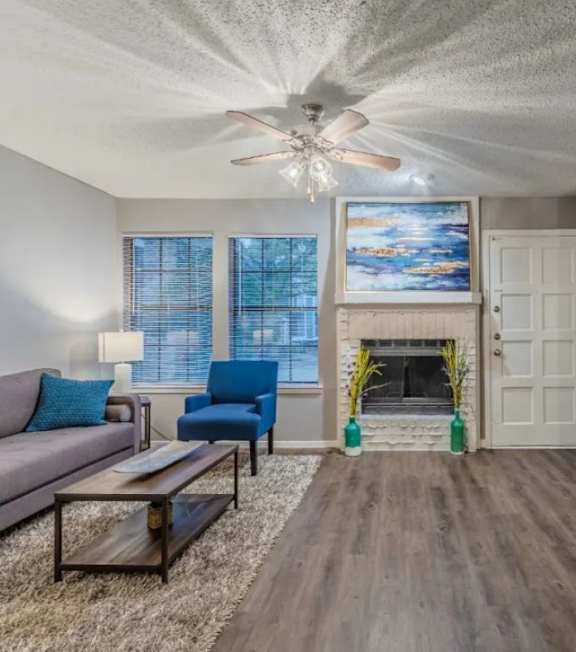 A living room with a fireplace and a painting above it.