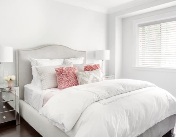 a bedroom with a bed and a lamp with a plant on it
