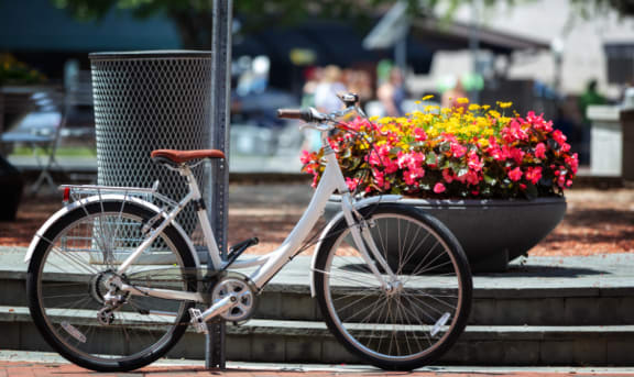 a bike parked next to a pole on a sidewalk