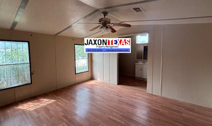 A room with wooden flooring and a ceiling fan.