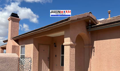 A house with a pink stucco exterior and a white door.