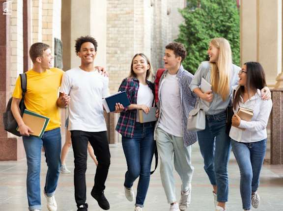 a group of students walking through a university hall