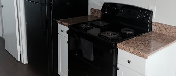a kitchen with white cabinets and black appliances