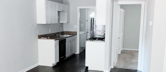 a kitchen with white cabinets and black appliances