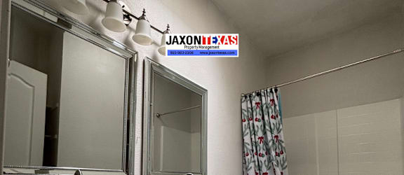 A bathroom with a sink, mirror, toilet, and shower.
