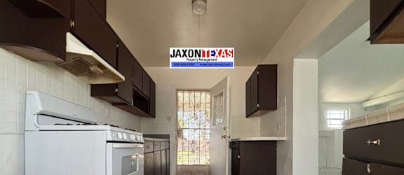 A kitchen with a white oven and brown cabinets.