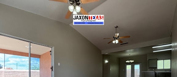 A room with a ceiling fan and a sign that says "JaxonTexas".