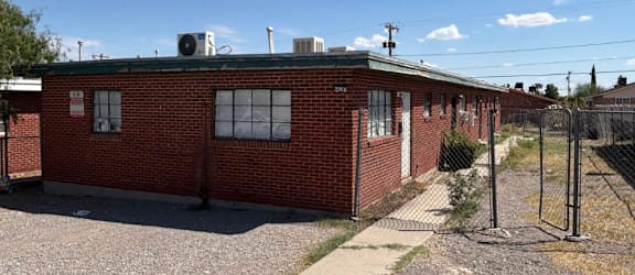 A red brick building with a white window and a sign that says JAXONILEXAS.