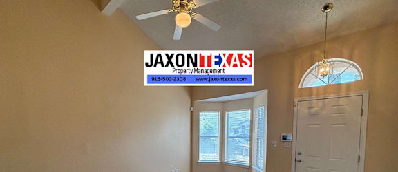 A room with a carpet floor and a ceiling fan.
