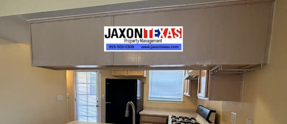 A kitchen area with a countertop and a sign that says "JASONTEXAS Property Management".