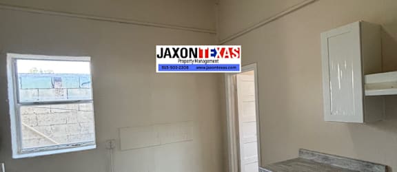 A room with a JAXON REAL ESTATE sign on the wall.
