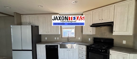A kitchen with a JAXONLEXAS sign hanging above it.
