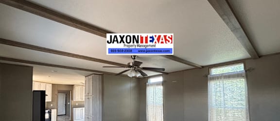 A room with a ceiling fan and a sign that says "Jaxontexas" is shown.
