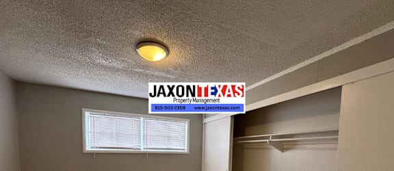 A room with a sign that says "Jaxon Property Management" on the wall.