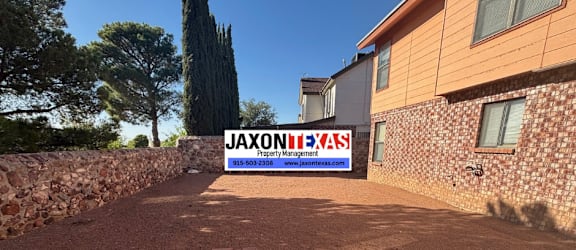 A sign for JaxonTexas is displayed in front of a building.