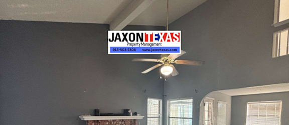 A living room with a fireplace and a ceiling fan.