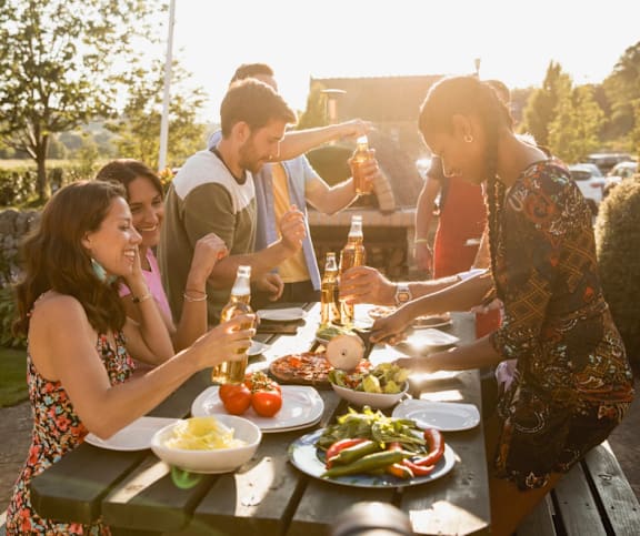 A group of people enjoying a meal and drinks together outdoors.