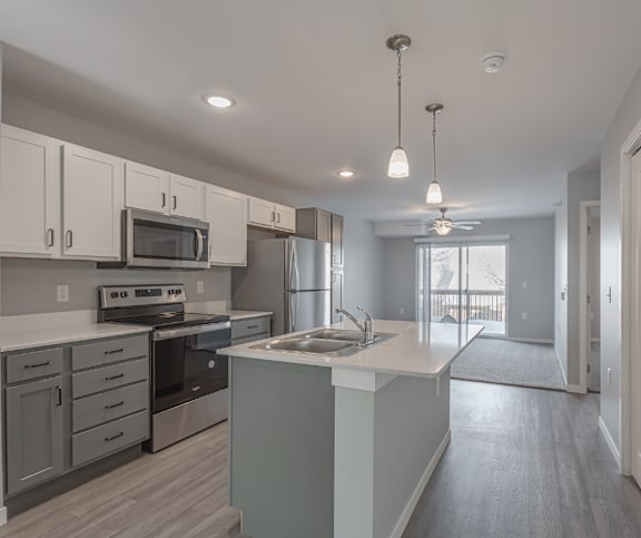 A modern kitchen with a stainless steel refrigerator and a microwave oven.