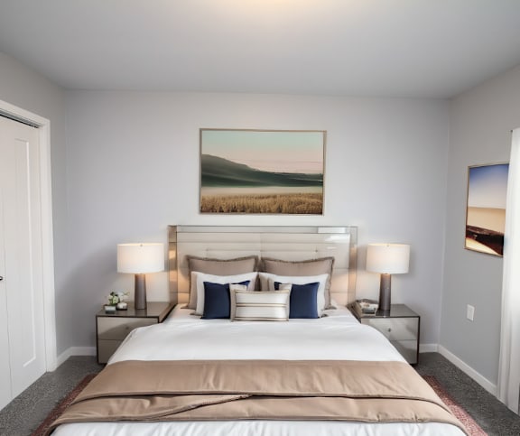 A bedroom with a large bed and a painting on the wall.