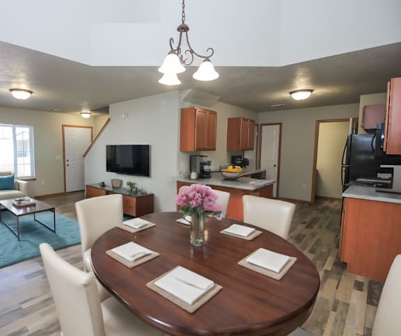 A dining room with a wooden table set for four.