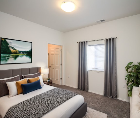 A bedroom with a large bed and a painting on the wall.