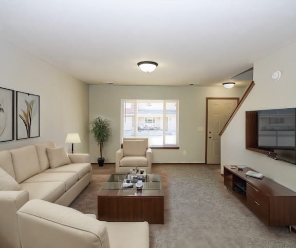 Modern living room with a white couch and mounted TV.