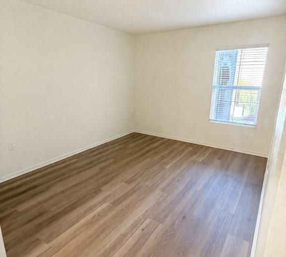 A room with wooden flooring and a white door.