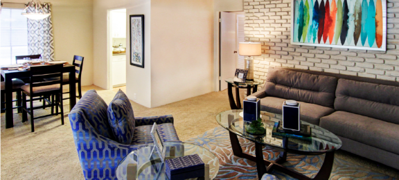 Spacious living room and dining room with white brick feature wall at Plantation apartments near the Galleria in Houston.