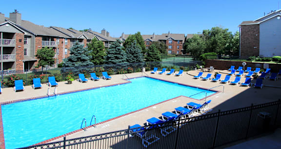 Apartments in central Lincoln Nebraska with beautiful landscaping, scenic views, large balconies, spacious balconies, huge swimming pool, and pool-side lounge chairs at Tanglewood Apartments