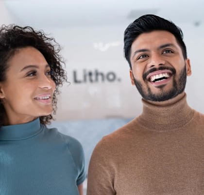 A man and a woman are standing close to each other, smiling.